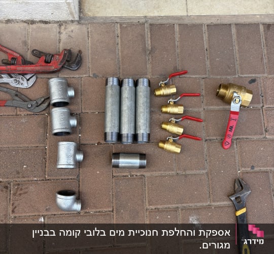 כלי עבודה וחלקי צנרת על רצפה